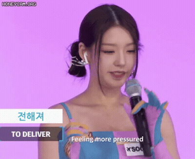 Woman In Pink And Blue Dress Holding Microphone Saying Feeling More Pressured GIF