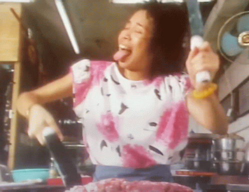 Woman In Pink And White Shirt Sticking Tongue Out Holding Knife GIF