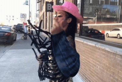 Woman In Pink Cowboy Hat With Sign B GIF