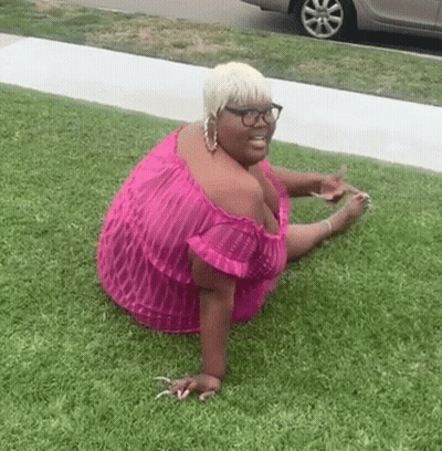 Woman In Pink Dress And Glasses Sitting On Grass GIF