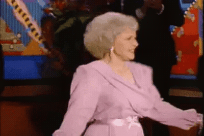 Woman In Pink Dress Dancing In Front Of Television GIF