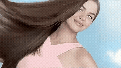 Woman In Pink Dress Holding Hair In Air Smiling GIF