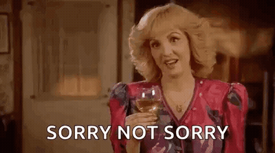 Woman In Pink Dress Holding Wine Saying Sorry Not Sorry GIF