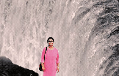 Woman In Pink Dress In Front Of Waterfall GIF