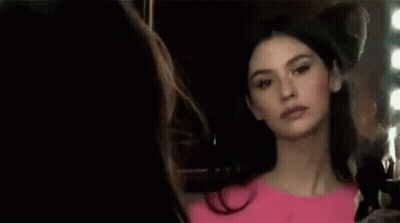Woman In Pink Dress Looking In Mirror GIF