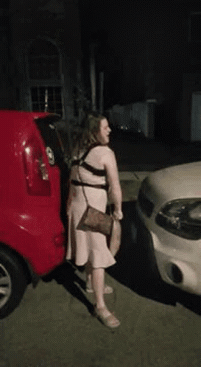 Woman In Pink Dress Next To Red Car GIF