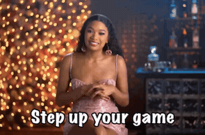 Woman In Pink Dress Saying Step Up Your Game By Christmas Tree GIF