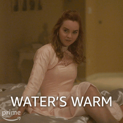 Woman In Pink Dress Sitting On Bed Water's Warm GIF