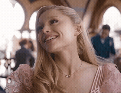 Woman In Pink Dress Smiling With J Necklace GIF