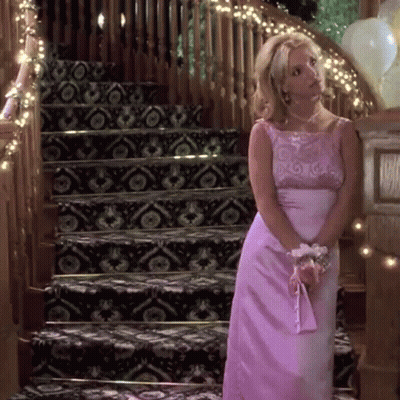 Woman In Pink Dress Standing In Front Of Stairs GIF