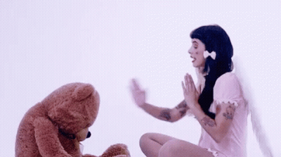 Woman In Pink Dress Waving To Teddy Bear GIF