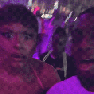 Woman In Pink Dress With Purple Lights In Dark Room GIF