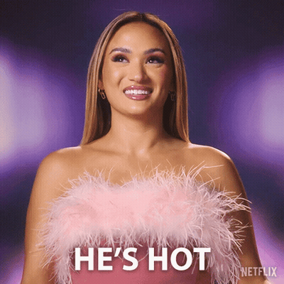 Woman In Pink Feathered Top Saying He's Hot GIF