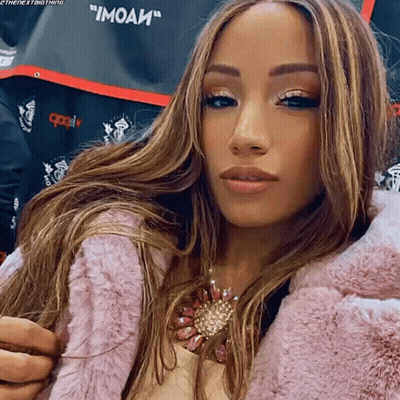 Woman In Pink Fur Coat With Moai Shirt GIF