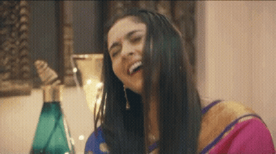 Woman In Pink Gold Sari Laughing Hair In Mouth GIF
