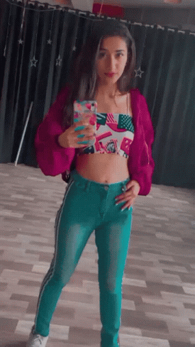 Woman In Pink Jacket And Blue Jeans Taking Selfie GIF