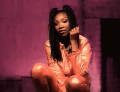 Woman In Pink Jacket And Orange Pants Squatting GIF