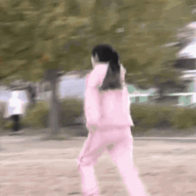 Woman In Pink Jacket And Pink Pants Walking In Park GIF