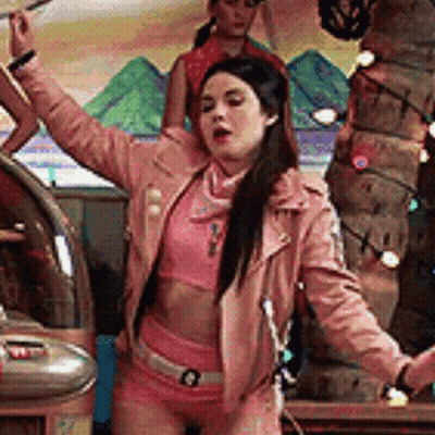 Woman In Pink Jacket And Shorts Dancing With Arms In Air GIF