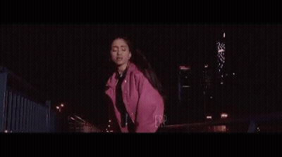 Woman In Pink Jacket Dancing On Bridge At Night GIF