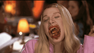Woman In Pink Jacket Eating Spaghetti With Mouth Full GIF