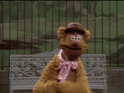 Woman In Pink Jacket Holding Cardboard Box Says What Is It This Time GIF
