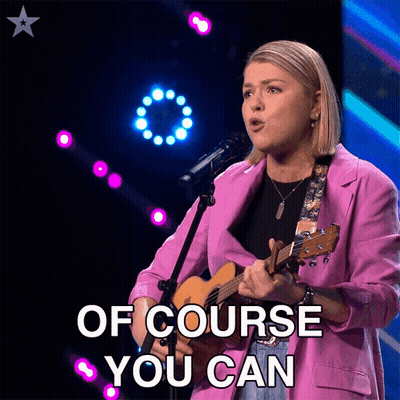 Woman In Pink Jacket Singing Into Microphone GIF