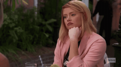 Woman In Pink Jacket Sitting At Table GIF