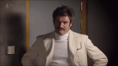 Woman In Pink Jacket Sitting In Front Of Lilly Sign GIF