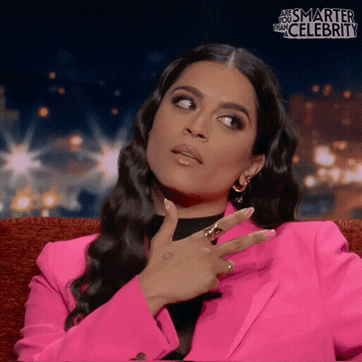 Woman In Pink Jacket Sitting On Couch Saying Are You Smarter Than Celebrity GIF