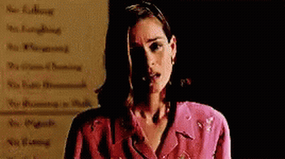Woman In Pink Jacket Standing In Front Of Rules GIF