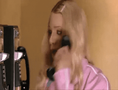 Woman In Pink Jacket Talking On Payphone GIF