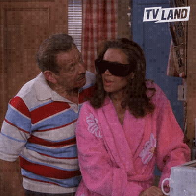Woman In Pink Robe And Sunglasses Beside Man In Striped Shirt TV Land Logo GIF