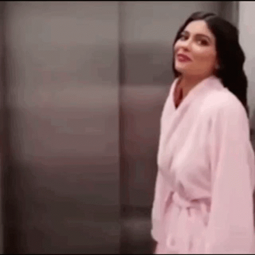 Woman In Pink Robe In Front Of Elevator GIF
