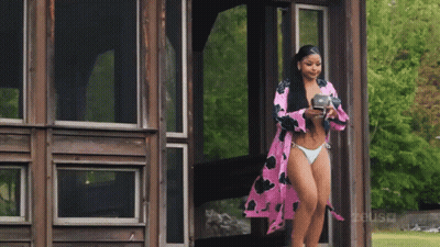 Woman In Pink Robe In Front Of Porch GIF