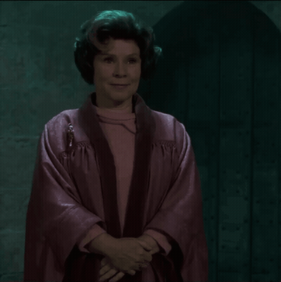 Woman In Pink Robe Smiling In Front Of Door GIF