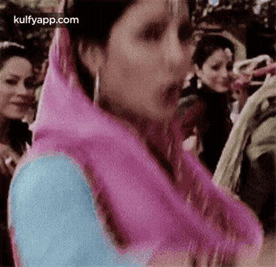 Woman In Pink Scarf Standing Before Crowd GIF
