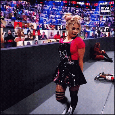 Woman In Pink Shirt And Black Skirt In Front Of Diva Digital Screen GIF