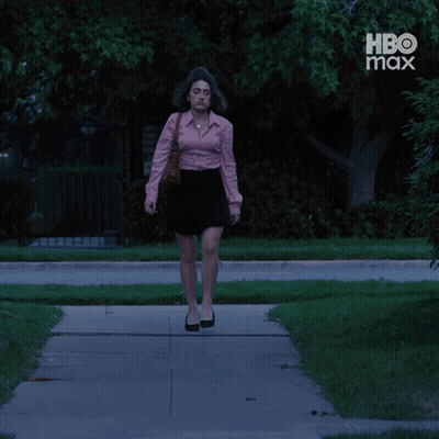 Woman In Pink Shirt And Black Skirt Walking Past HBO Max Ad GIF