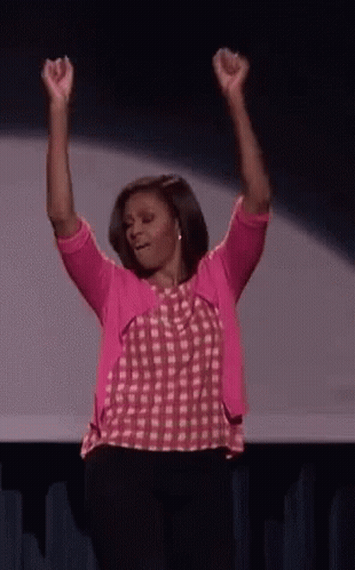 Woman In Pink Shirt And Cardigan Raising Arms GIF