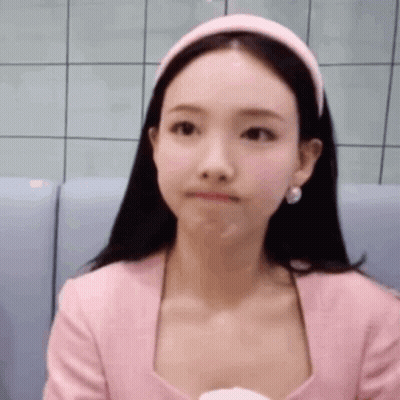Woman In Pink Shirt And Headband Sitting On Couch GIF