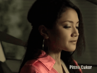 Woman in Pink Shirt and Hoop Earrings With Pisau Ukur