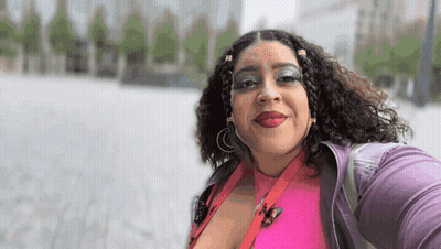 Woman In Pink Shirt And Purple Jacket Smiling GIF