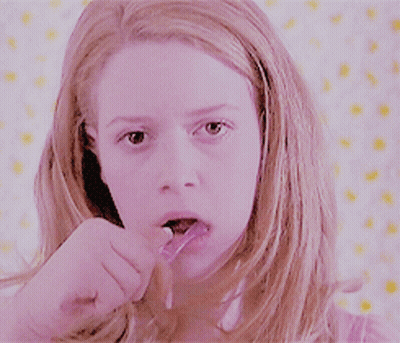 Woman In Pink Shirt Brushing Teeth GIF