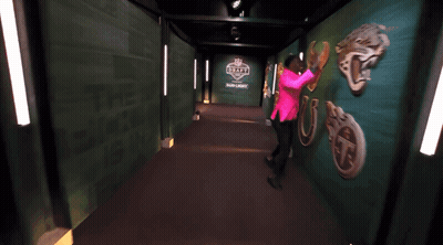 Woman In Pink Shirt Dancing In Hallway With Draft GIF