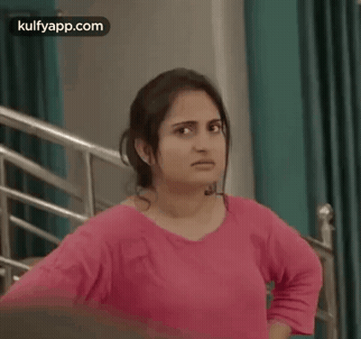 Woman In Pink Shirt Hands On Hips By Staircase GIF