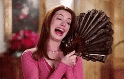 Woman In Pink Shirt Laughing Holding Fan GIF
