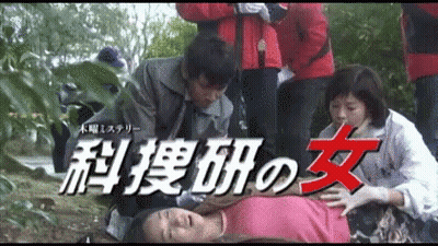 Woman In Pink Shirt Laying On Ground Surrounded By People With Chinese Writing GIF