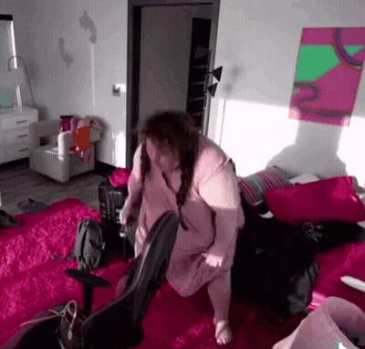 Woman In Pink Shirt Standing On Bed GIF