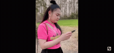 Woman In Pink Shirt Standing On Dirt Road In Field GIF